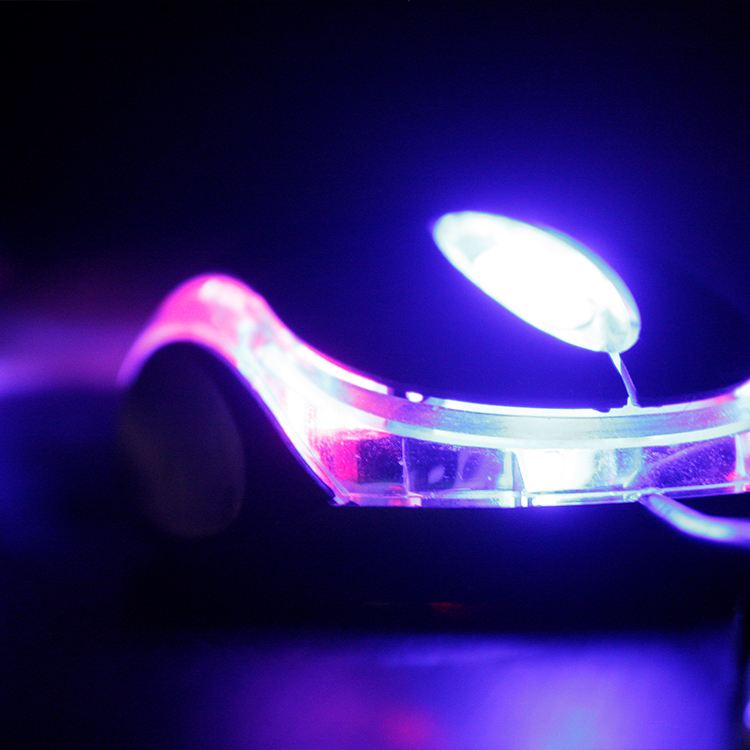 A glowing device lit in blue and pink
